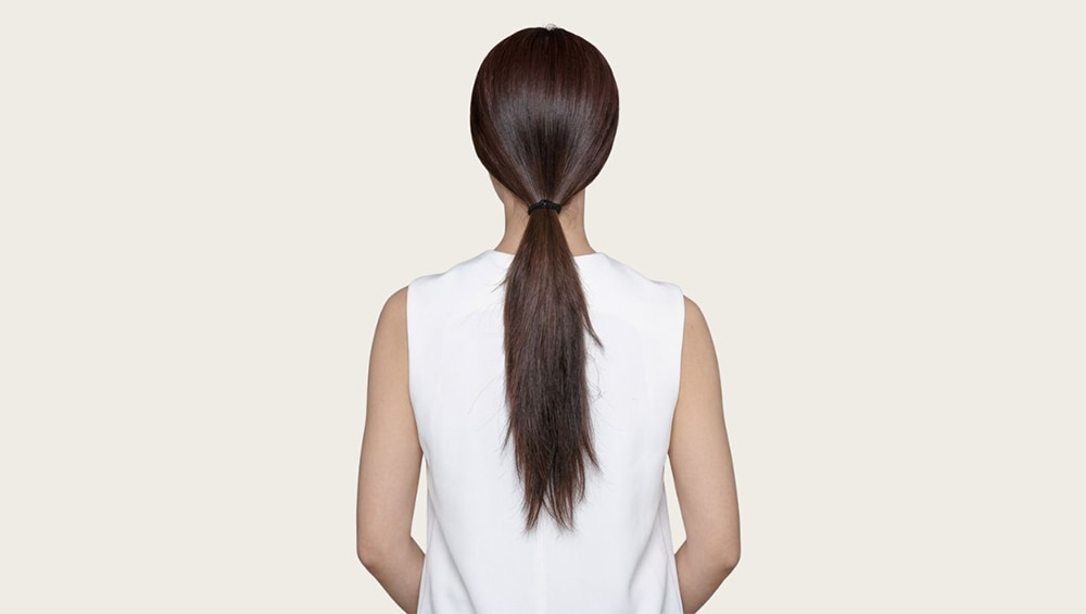 Cột tóc ra sau gáy khi còn hơi ẩm là cách đơn giản giúp định hình và giữ tóc vào nếp suôn mượt.
